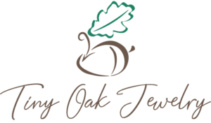 A logo for Tiny Oak Jewelry, featuring a stylized acorn graphic.