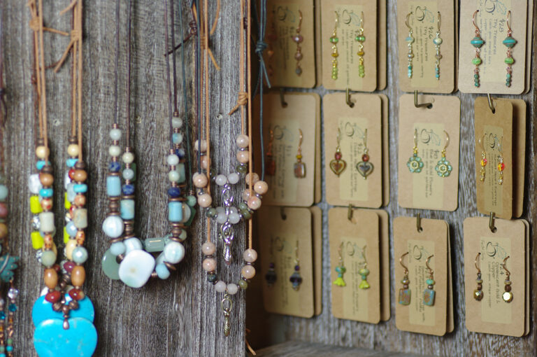 A display of necklaces and earrings made from glass, ceramic and gemstones