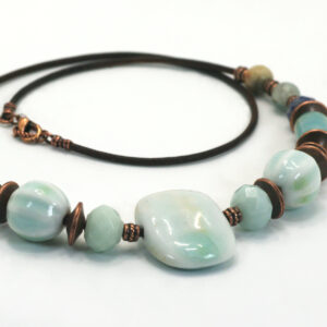 A leather cord necklace with blue ceramic and gemstone beads.