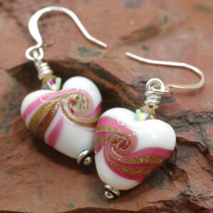 Earrings made of glass heart beads swirled with pink and gold.