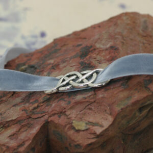 A blue velvet choker with a silver infinity symbol.